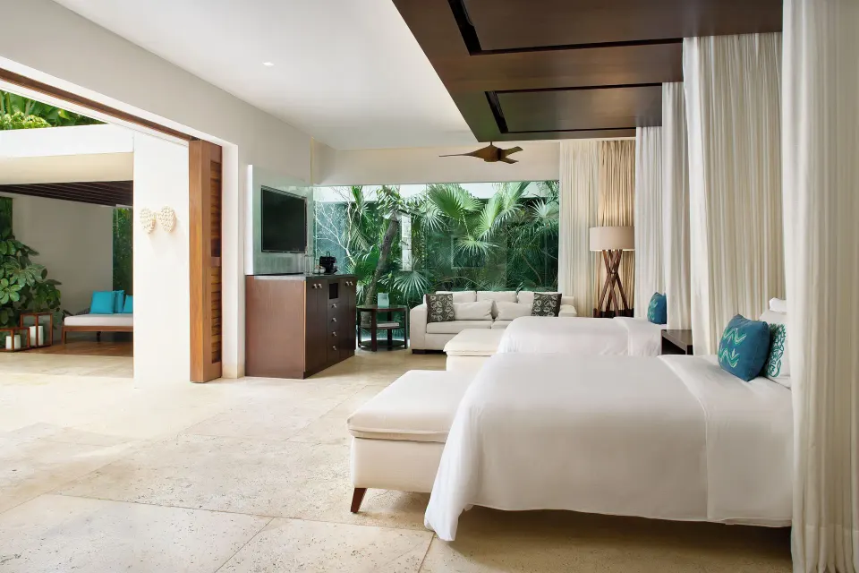 Open-plan suite with king bed, seating area and garden view at Chablé Yucatán