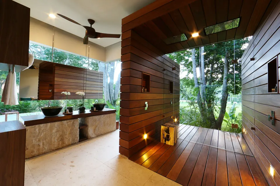 Open spa area with wooden sauna-style stalls and large windows at Chablé Yucatán