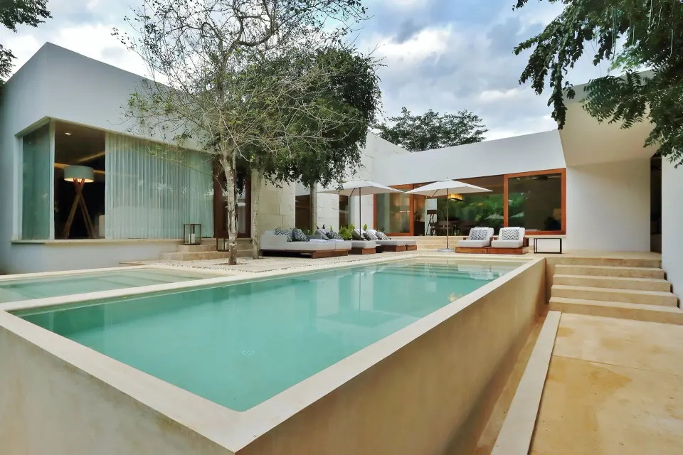 Private courtyard pool with sun loungers and villa facade at Chablé Yucatán