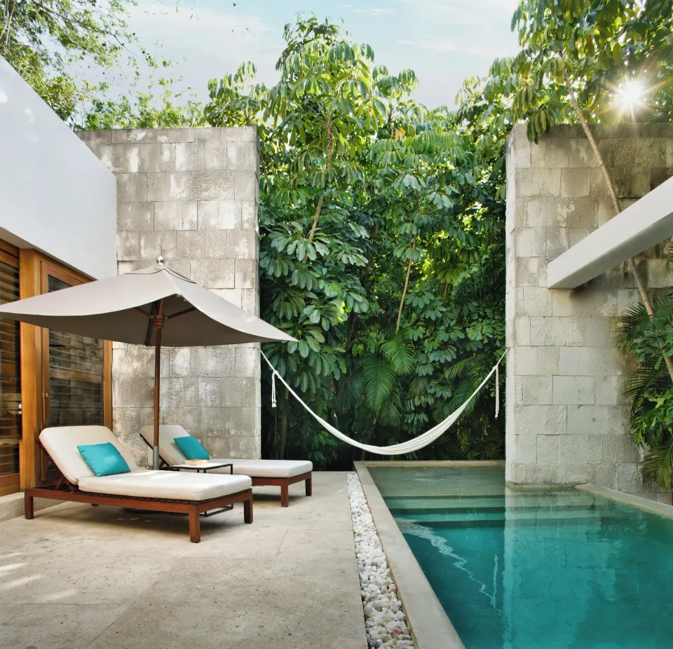 Narrow private pool with lounge chairs, umbrella and hammock at Chablé Yucatán