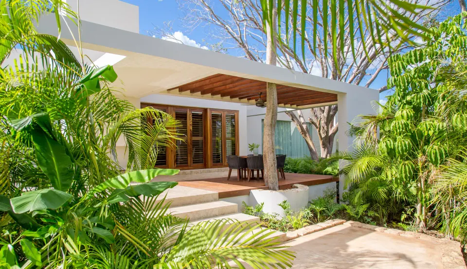 Private villa exterior with shaded wood pergola and lush tropical planting at Chablé Yucatán