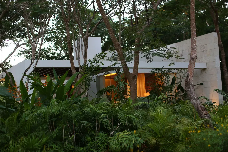 White modern villa partially hidden by tropical foliage at Chablé Yucatán