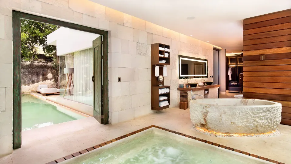 Luxury bathroom with freestanding stone tub and direct pool access at Chablé Yucatán