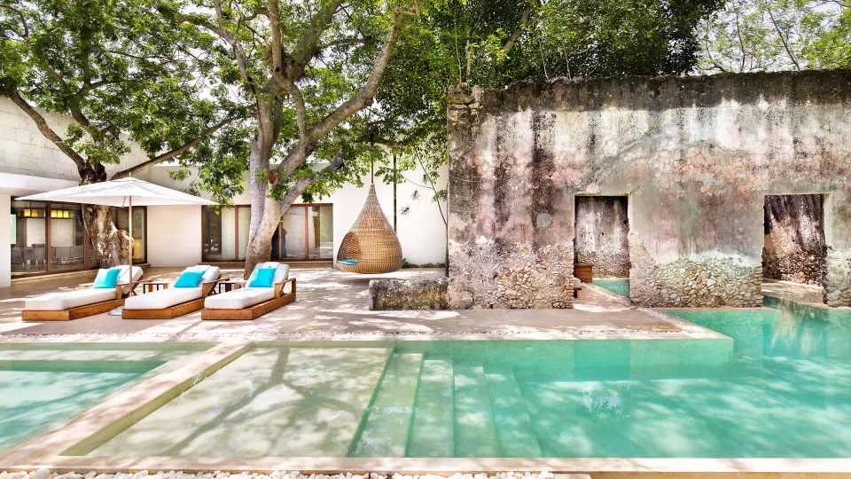 Private terrace with loungers and plunge pool beside a stone wall at Chablé Yucatán