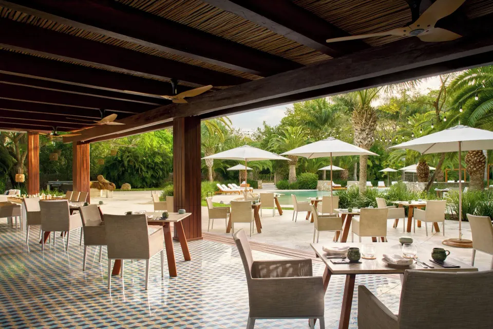 Covered poolside dining with tiled floor and ceiling fans at Chablé Yucatán