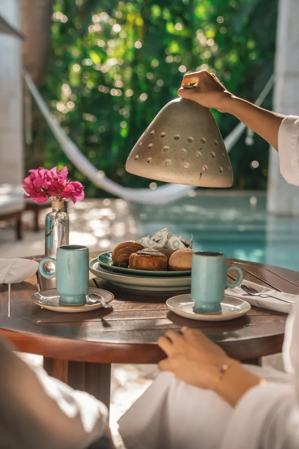 Poolside breakfast table with cloche and hammock in background at Chablé Yucatán