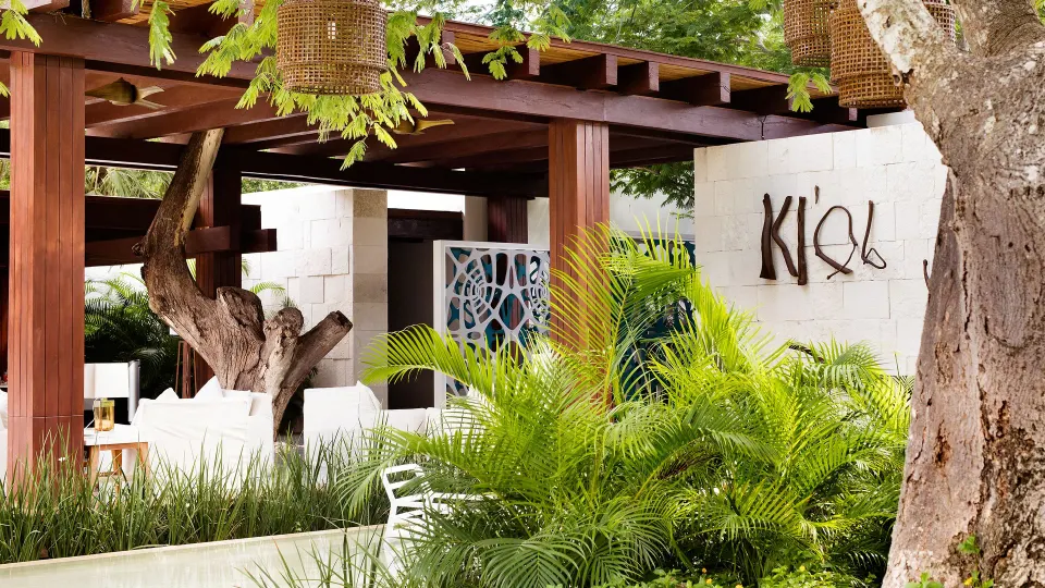 Outdoor lounge and entry wall with sign reading K’ial at Chablé Yucatán