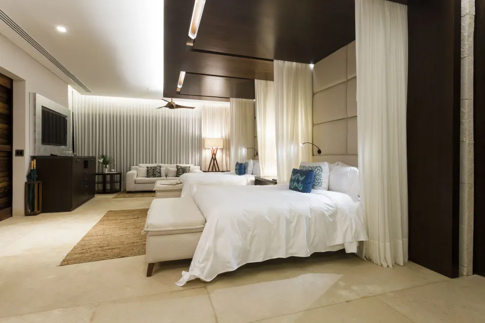 Family Villa suite with twin canopy beds and seating area at Chablé Yucatán