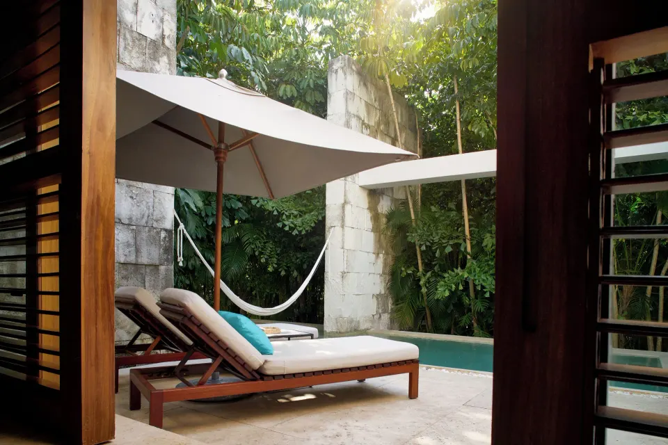 Private terrace with lounge chairs, umbrella and hammock by a plunge pool at Chablé Yucatán
