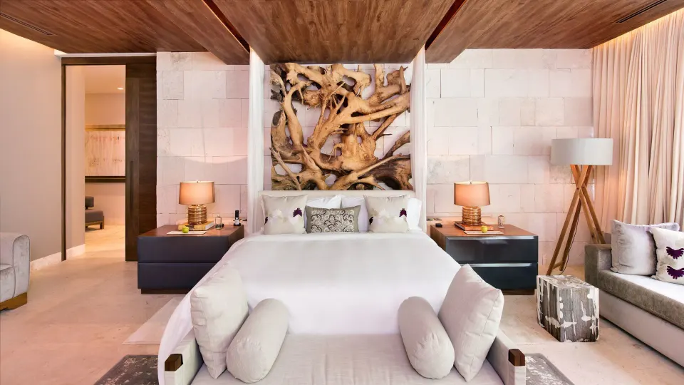 Front-facing view of a king bed with sculptural headboard in Royal Villa at Chablé Yucatán