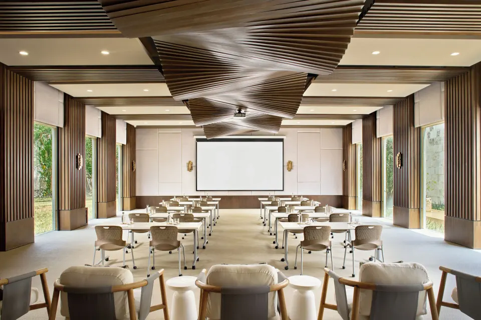 Bright meeting room set with chairs and projector screen at Chablé Yucatán