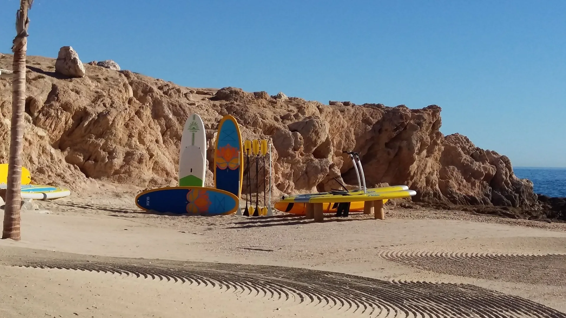 Beach paddleboards and kayaks on the sand at Chileno Bay Resort & Residences.