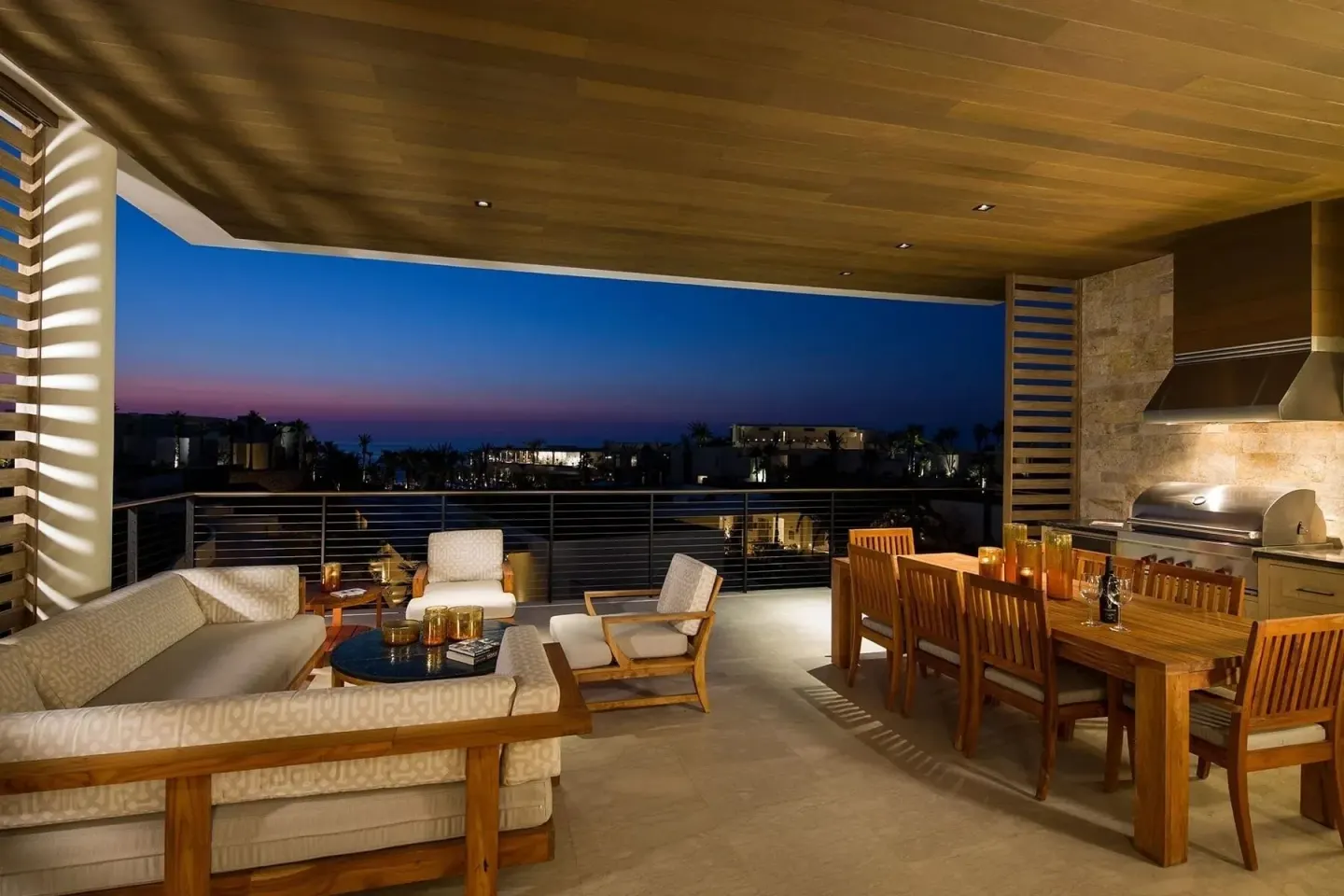 Covered terrace with seating, dining table and grill at Chileno Bay Resort & Residences.