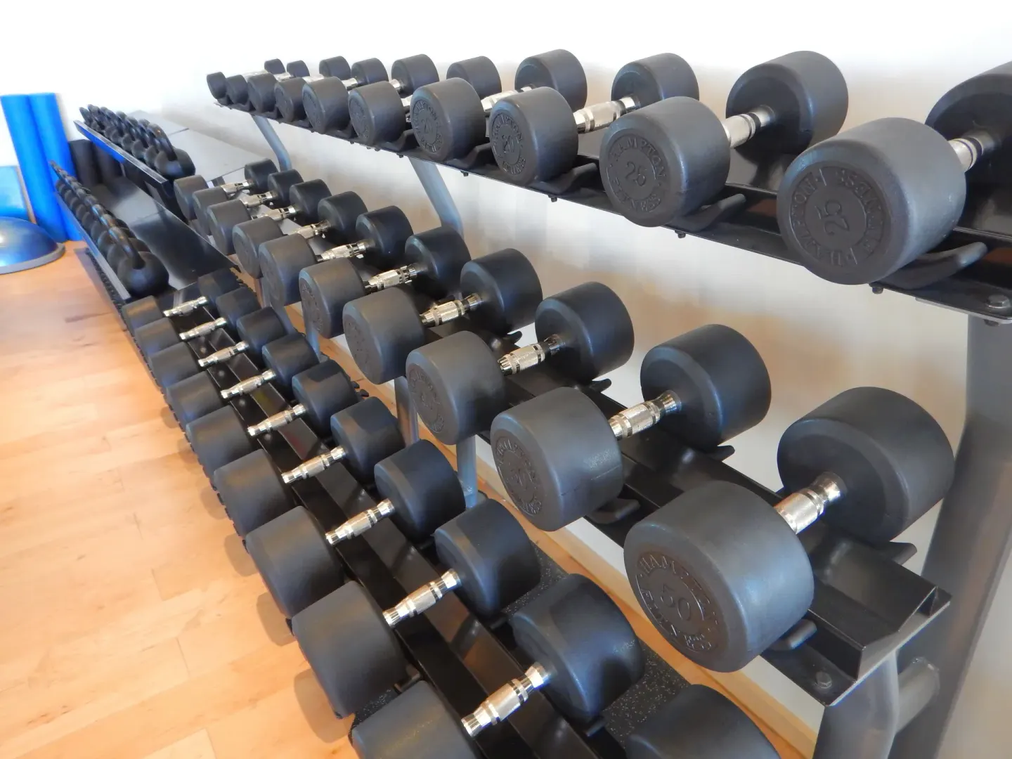 Rows of dumbbells on weight racks in the gym at Chileno Bay Resort & Residences.