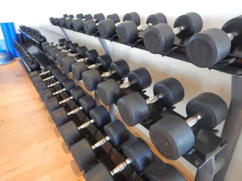 Rows of dumbbells on weight racks in the gym at Chileno Bay Resort & Residences.