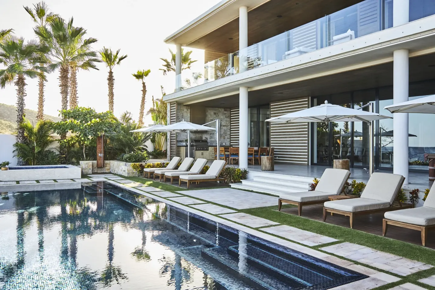 Private pool terrace with loungers and umbrellas at Chileno Bay Resort & Residences.