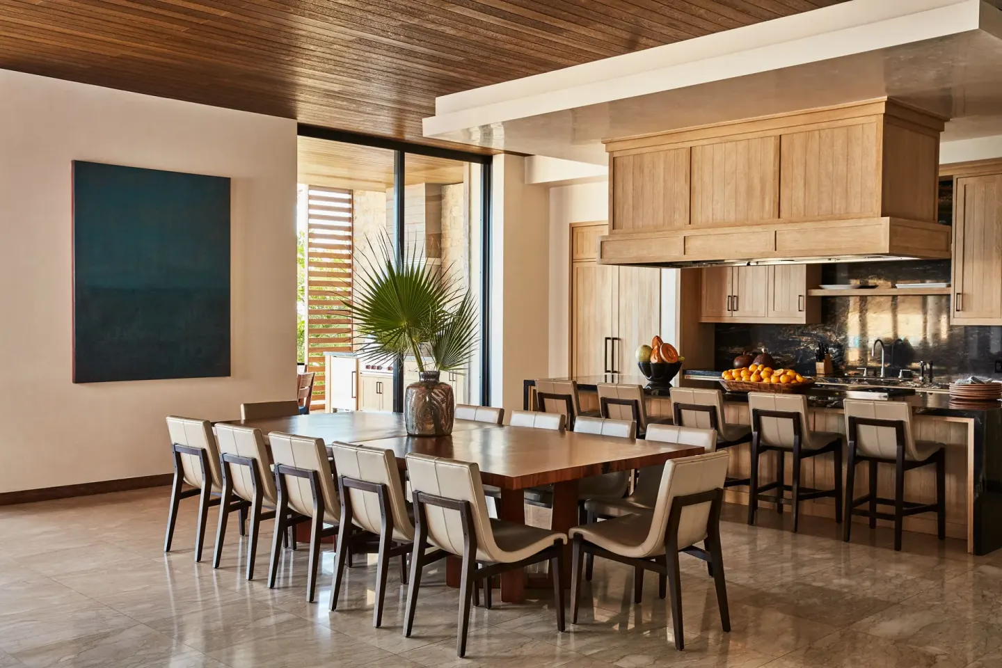 Large dining table and open kitchen in a residence at Chileno Bay Resort & Residences.