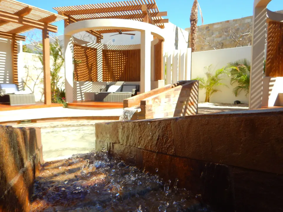 Spa courtyard with water feature and shaded cabanas at Chileno Bay Resort & Residences.