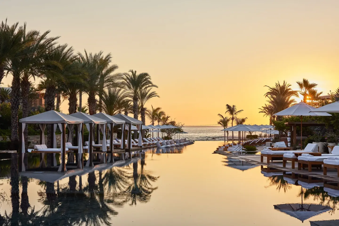 Sunset over the resort pool and ocean at Chileno Bay Resort & Residences.