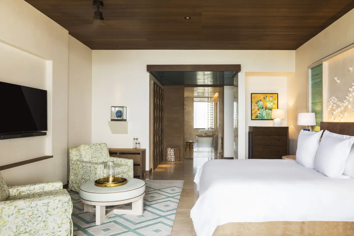 Garden View room with king bed, lounge chairs and bath beyond at Chileno Bay Resort & Residences.