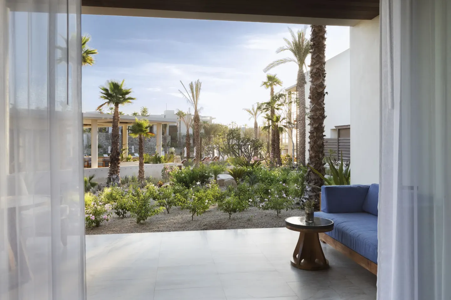 Garden View terrace with blue sofa and palm landscaping at Chileno Bay Resort & Residences.