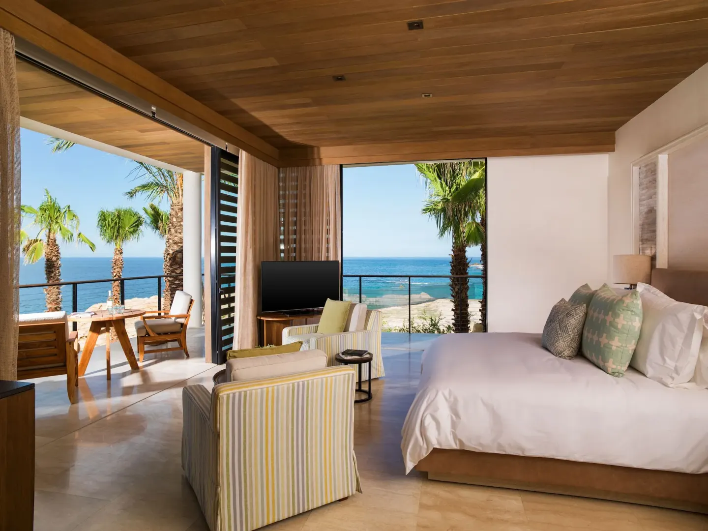 Bright oceanfront king room with balcony seating at Chileno Bay Resort & Residences.