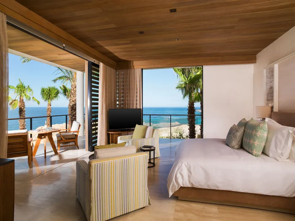 Bright oceanfront king room with balcony seating at Chileno Bay Resort & Residences.
