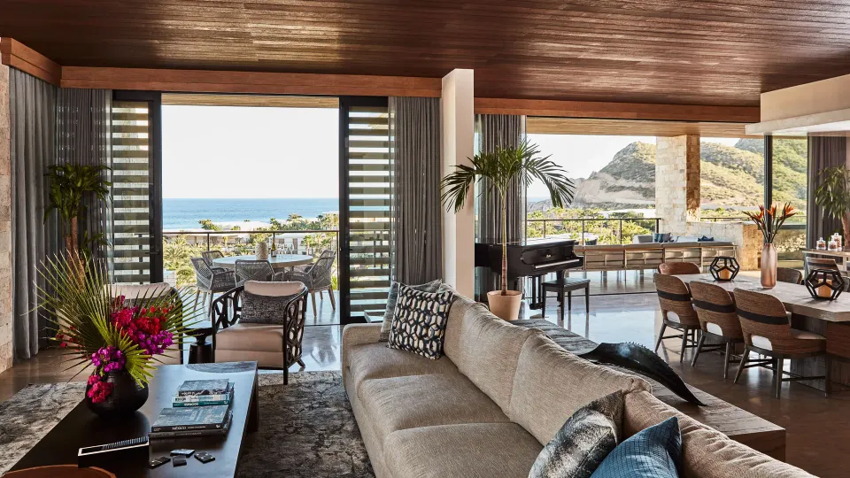 Living and dining room opening to ocean terraces at Chileno Bay Resort & Residences.