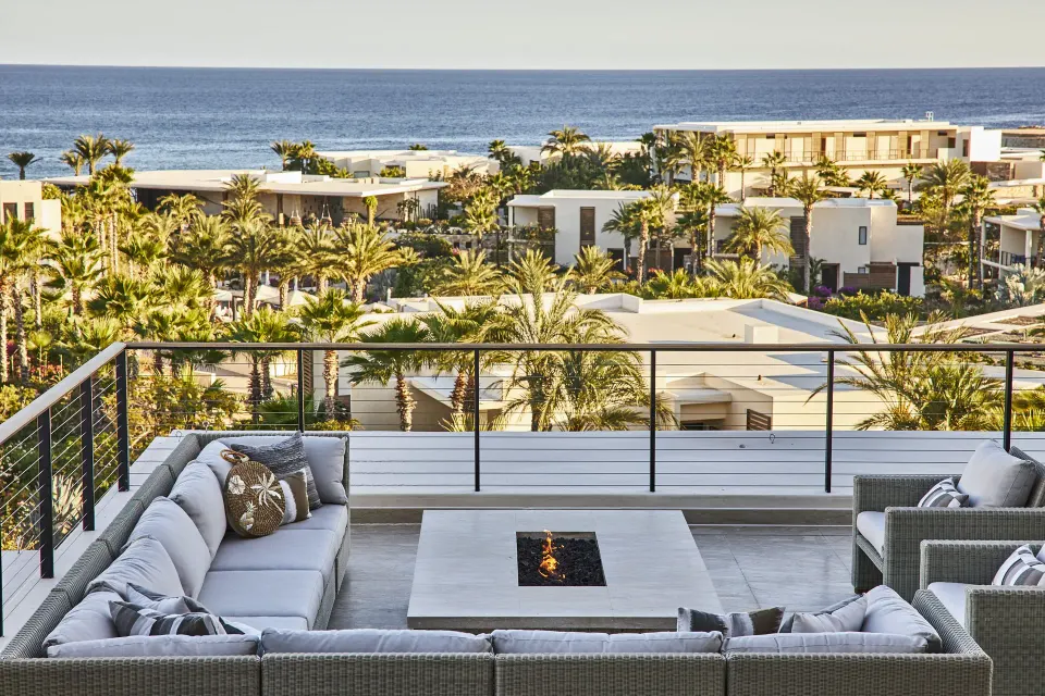 Signature Villa terrace seating at Chileno Bay Resort & Residences with palms and ocean in view.