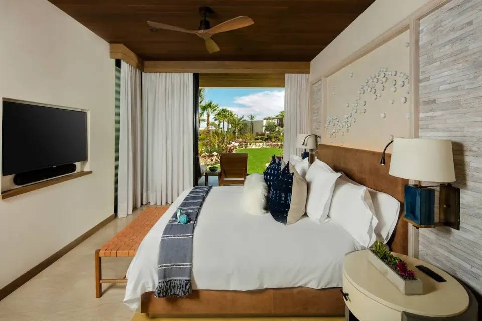 Garden View suite bedroom with king bed and patio at Chileno Bay Resort & Residences.