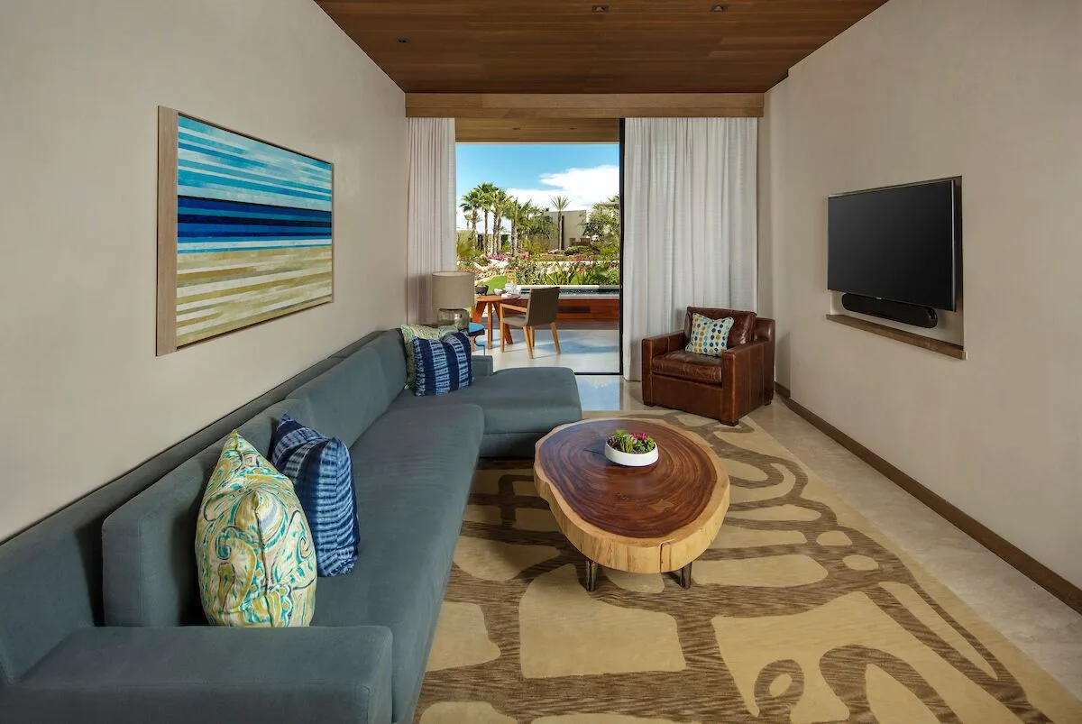 Garden View suite living room with sofa and terrace at Chileno Bay Resort & Residences.