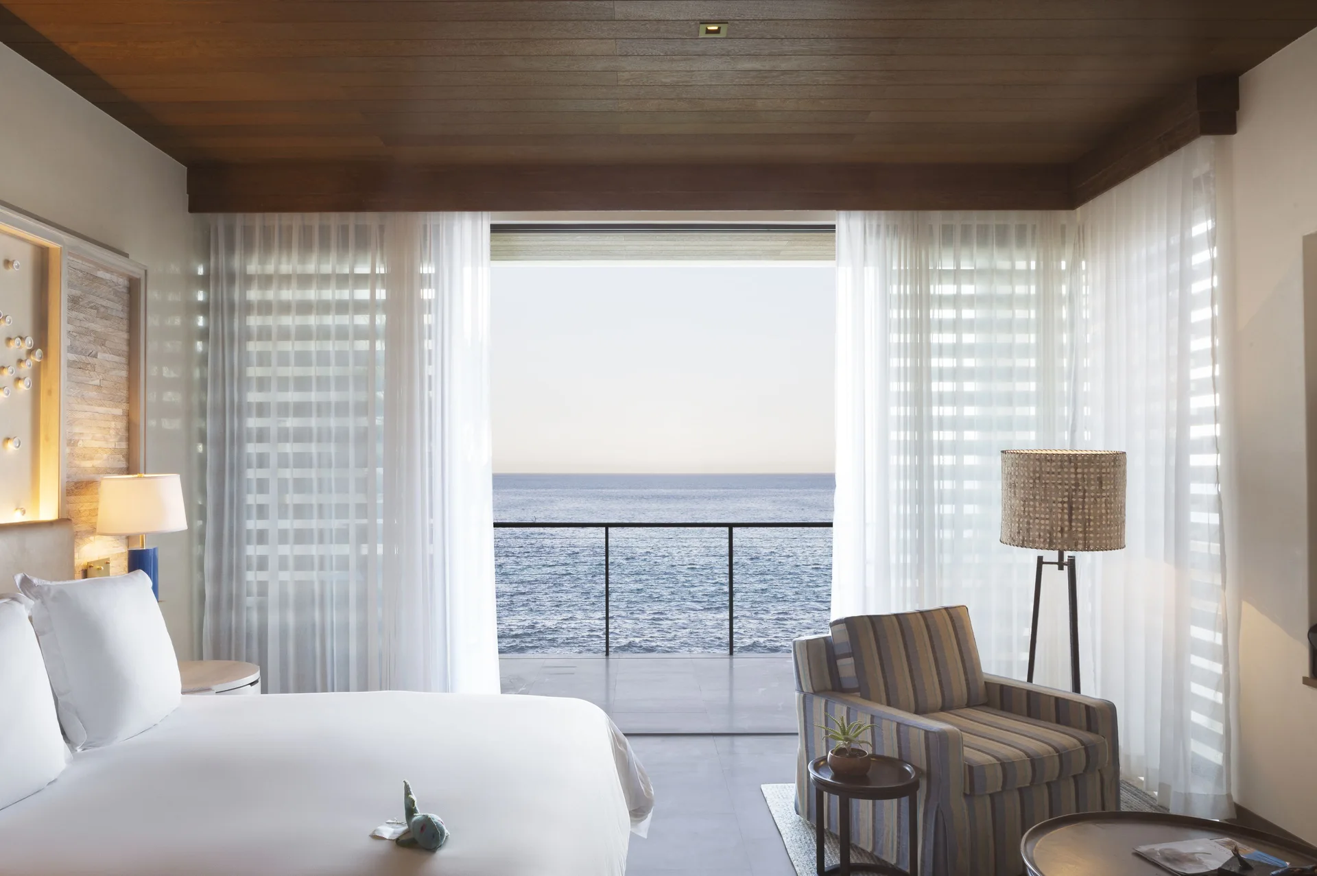 Oceanfront bedroom with king bed and balcony view at Chileno Bay Resort & Residences.