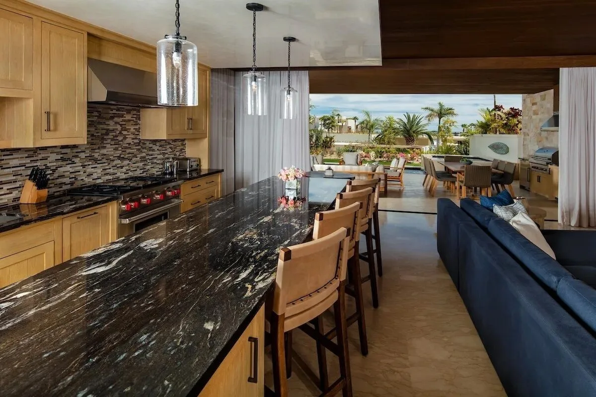 Open villa kitchen and living area with terrace view at Chileno Bay Resort & Residences.