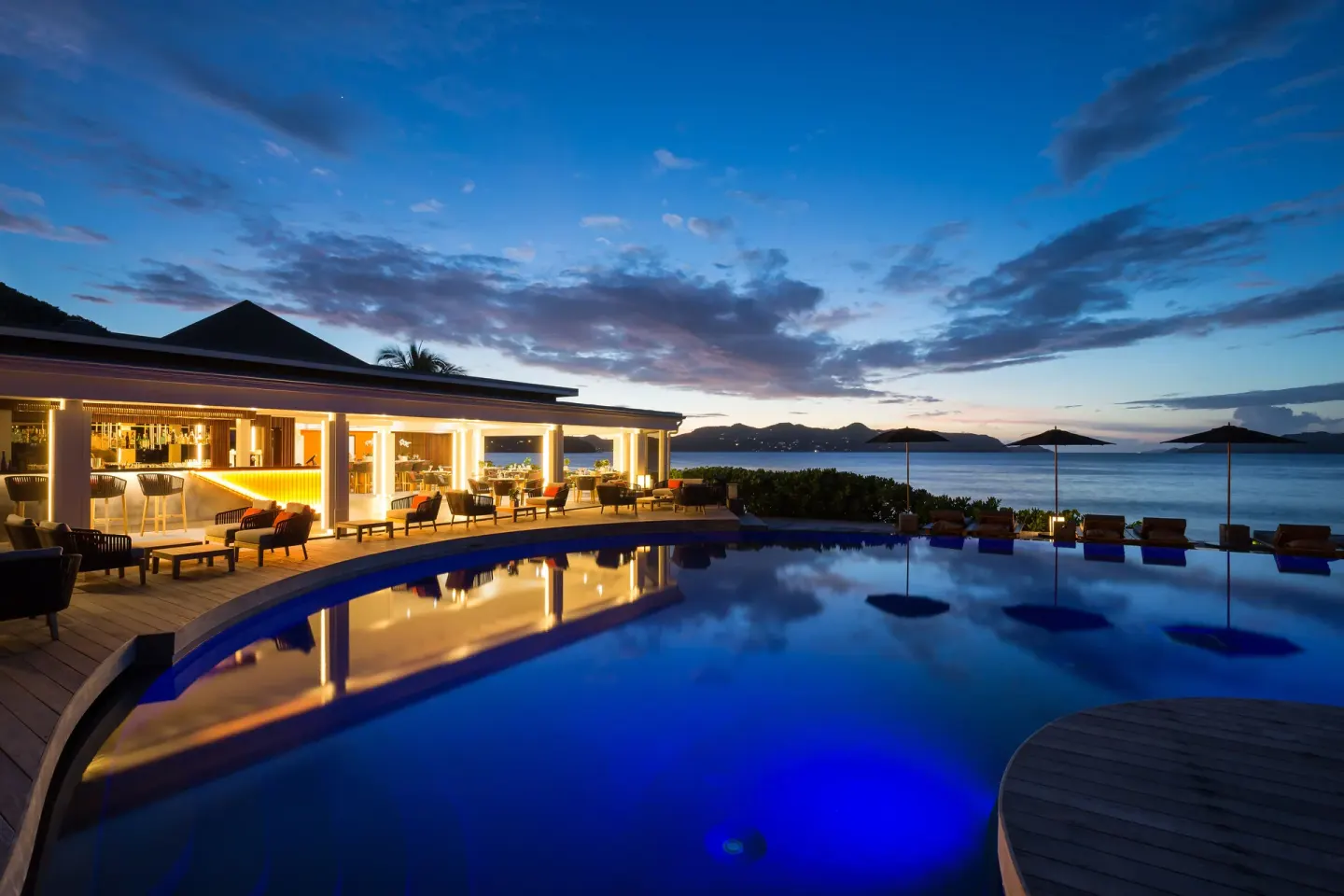 The illuminated pool and open-air lounge overlook the sea at Christopher Hotel.
