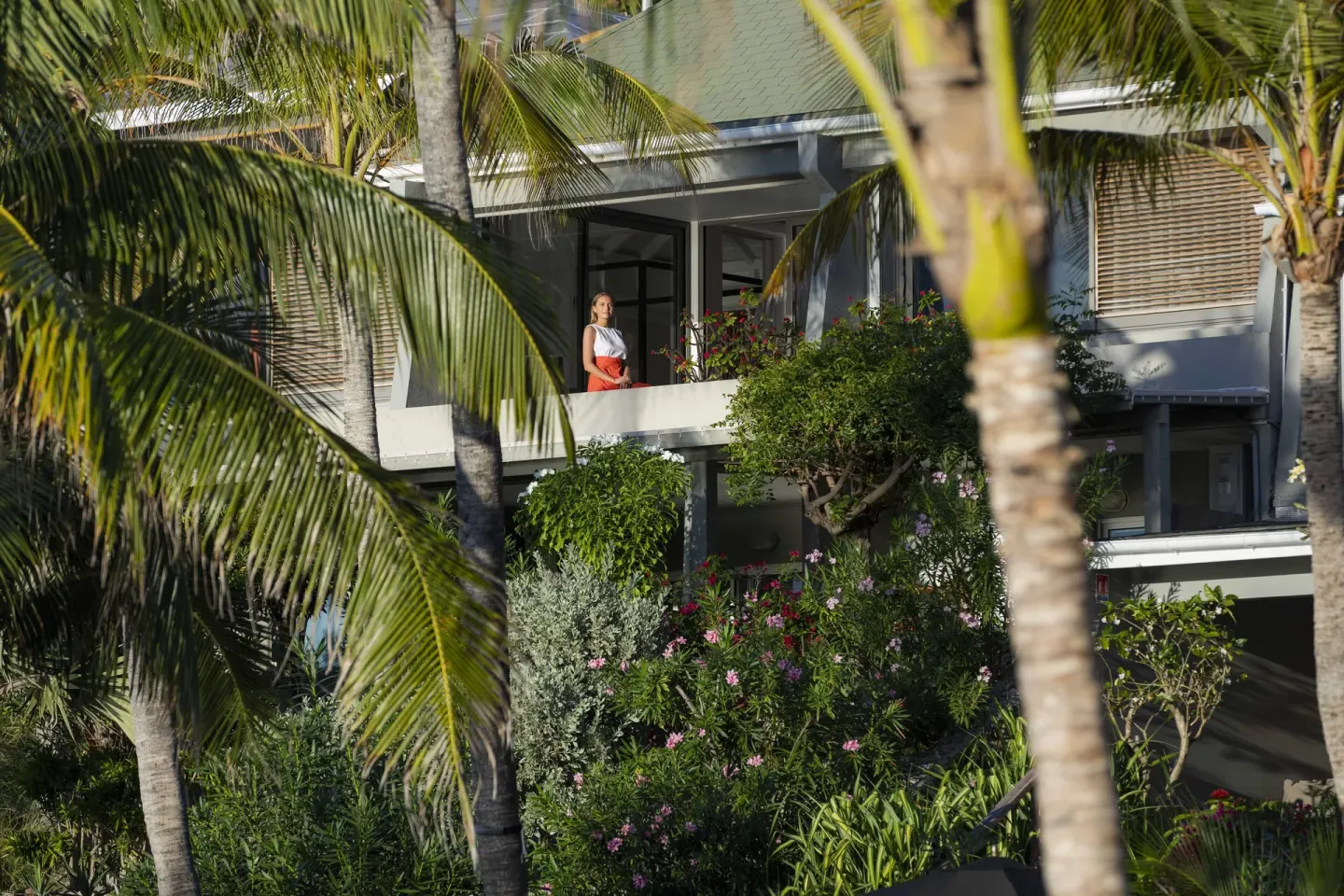 Guest balcony framed by palms and tropical gardens at Christopher Hotel.