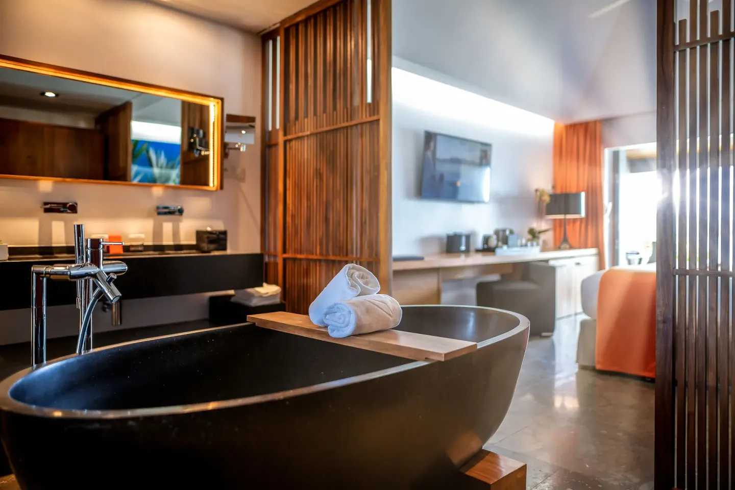 Freestanding black bathtub and open guest room bathroom at Christopher Hotel.
