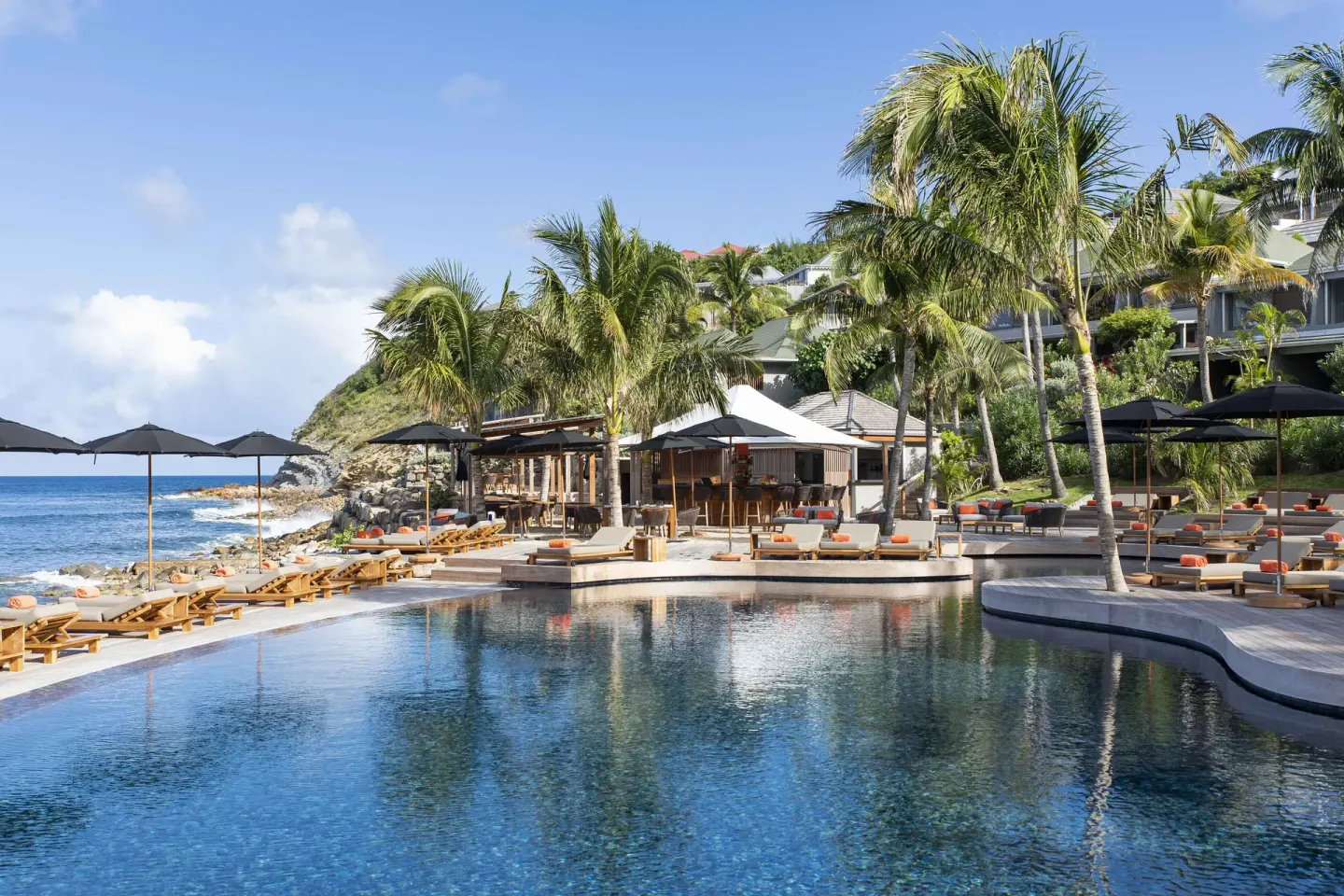 Oceanfront pool with palm trees, loungers, and sun deck at Christopher Hotel.