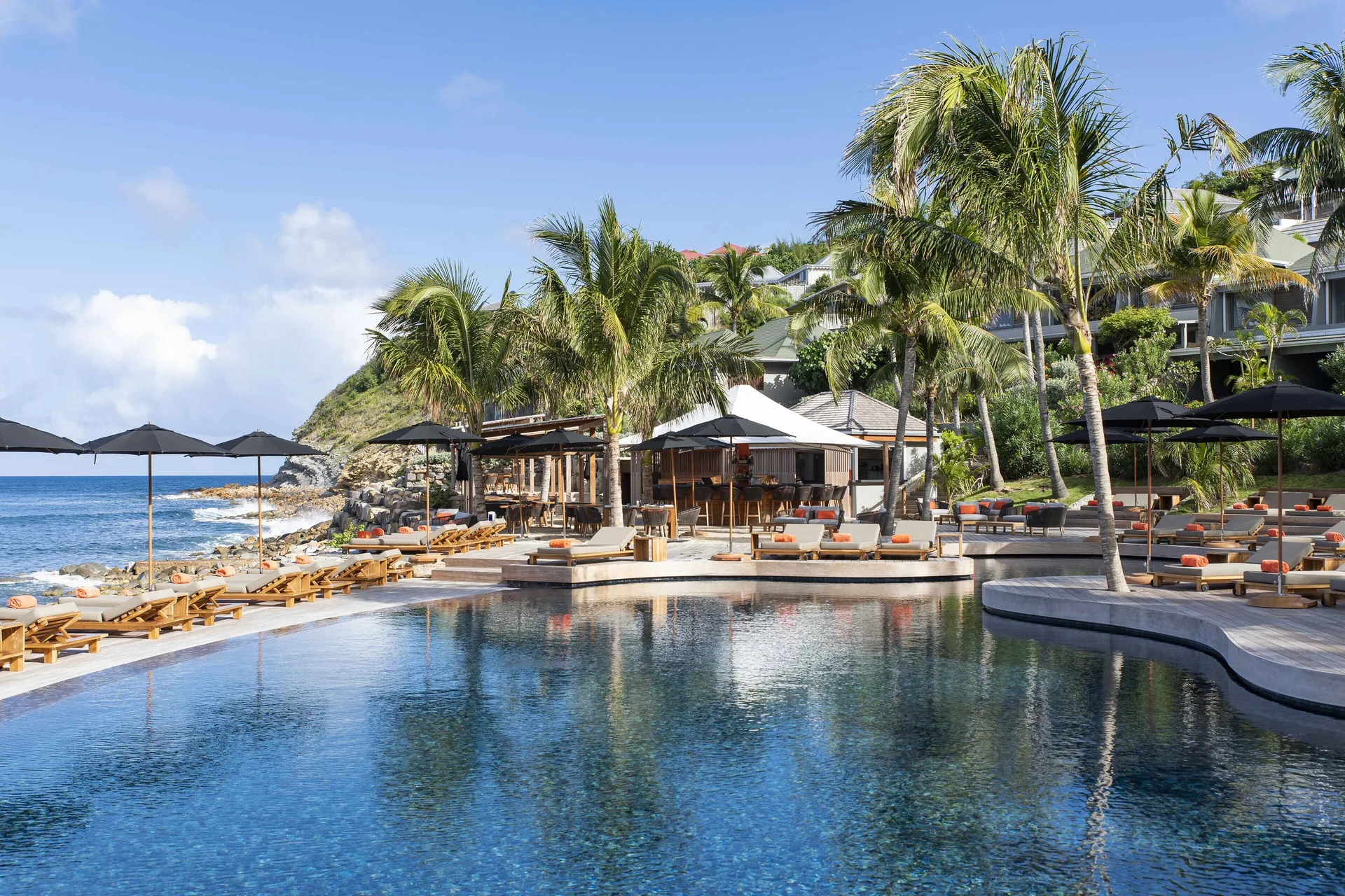 Oceanfront pool with palm trees, loungers, and sun deck at Christopher Hotel.