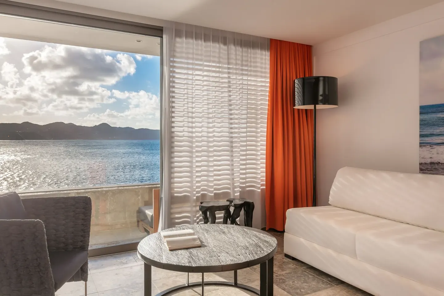 Guest room sitting area with sofa and ocean-facing balcony at Christopher Hotel.