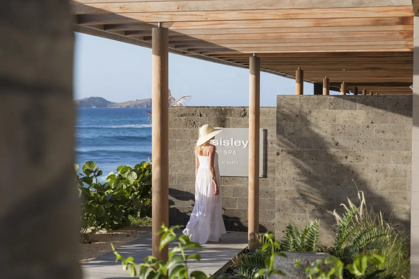 A covered seaside walkway leads past the spa entrance at Christopher Hotel.