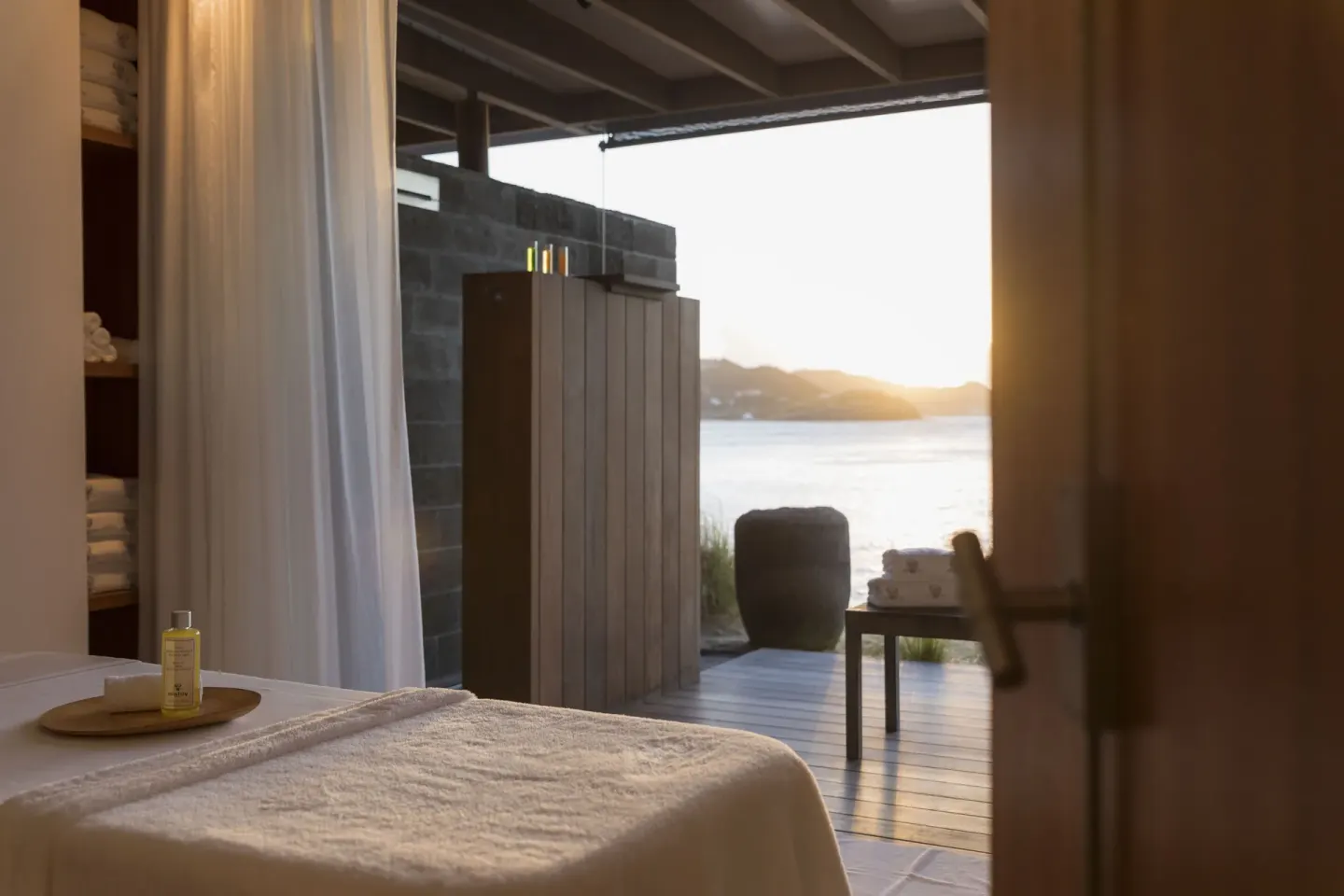 A spa treatment room opens to a deck and sunset sea view at Christopher Hotel.