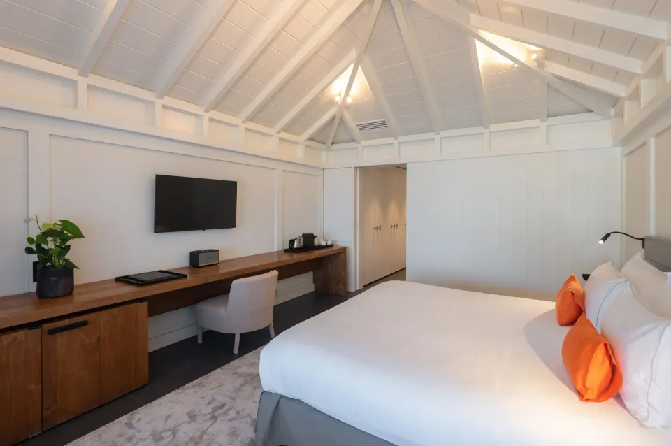 Deluxe room king bed, desk, and vaulted ceiling at Christopher Hotel.