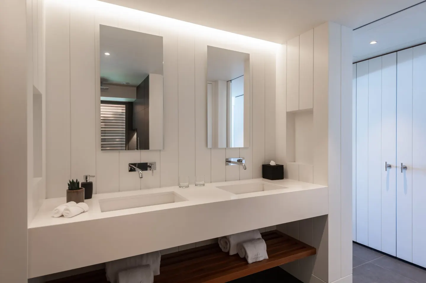 Deluxe room bathroom with double vanity and mirrors at Christopher Hotel.