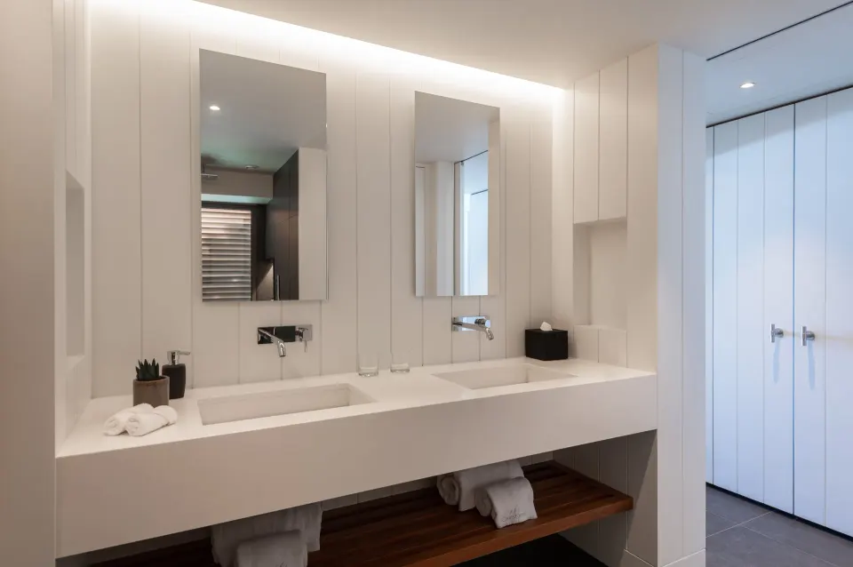 Deluxe room bathroom with double vanity and mirrors at Christopher Hotel.