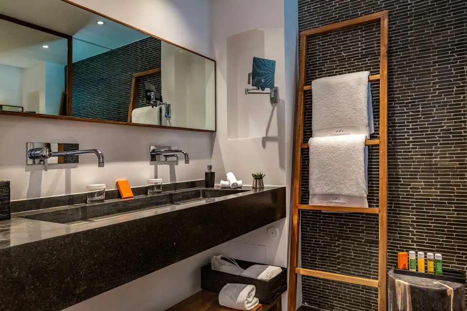 Junior Suite bathroom vanity with twin sinks, mirror and towels at Christopher Hotel.