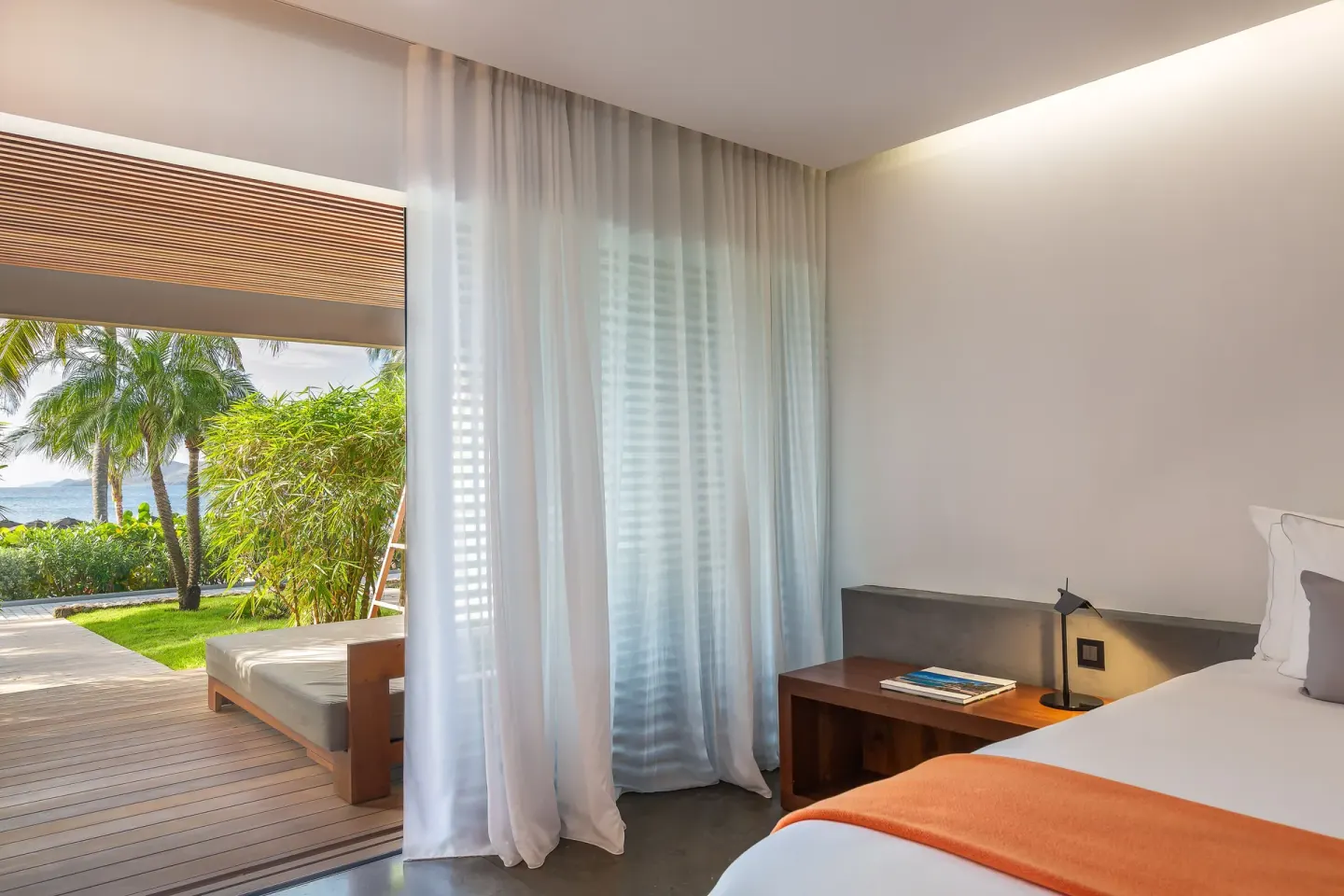 Terrace ocean room with bed, sheer curtains, and patio daybed at Christopher Hotel.