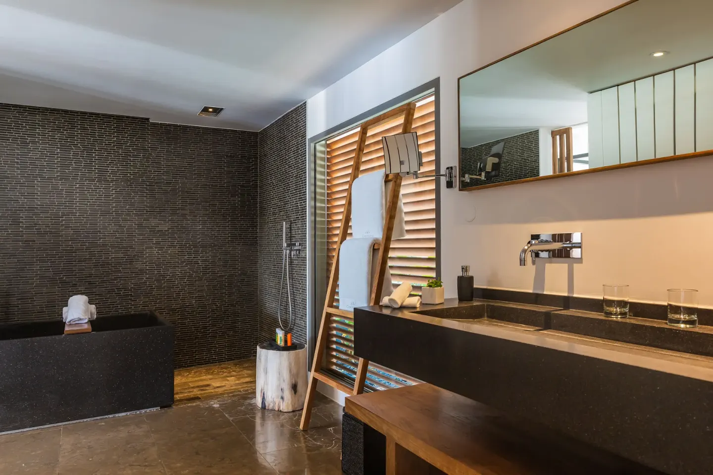 Ocean suite bathroom with soaking tub, shower, vanity, and mirror at Christopher Hotel.