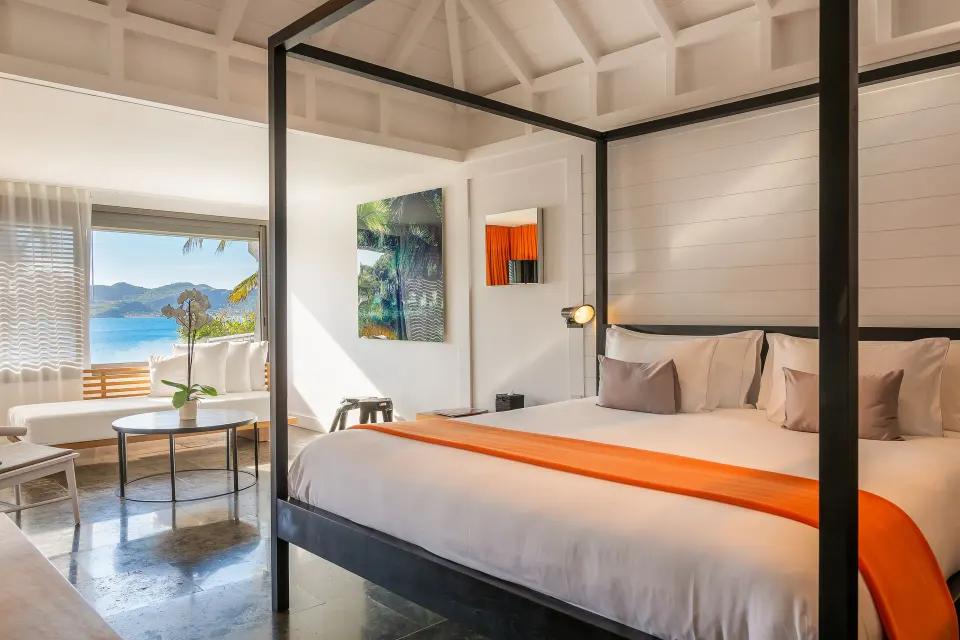Ocean suite bedroom with canopy bed and sea view at Christopher Hotel.