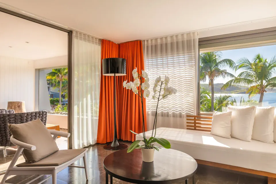 Ocean suite lounge with daybed, chair, orchid, and sea view at Christopher Hotel.