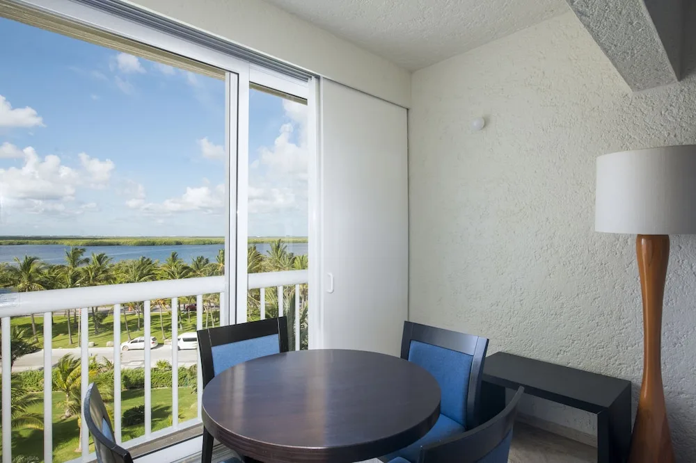 Dining table by balcony with lagoon and palm views at Club Regina Cancun.